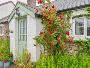 a house with red roses on the side of it at Goslings in Thornbury