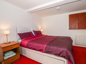 a bedroom with a large bed with a red carpet at 5 Firle Road Annexe in Lancing