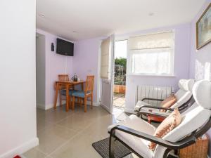 a living room with white chairs and a table at 5 Firle Road Annexe in Lancing