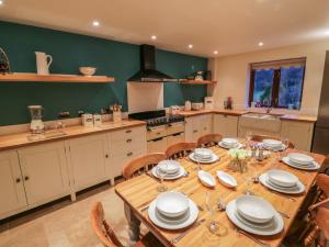 a large kitchen with a wooden table and chairs at Hill Bank in Lupton