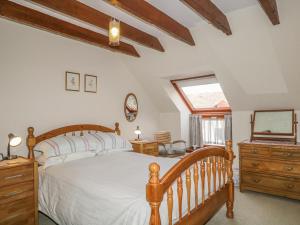 a bedroom with a bed and a dresser and a window at The Farm Steading in Aberlour