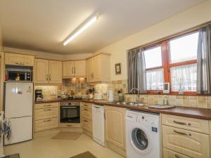 a kitchen with a washer and dryer at The Farm Steading in Aberlour