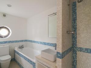 a bathroom with a tub and a toilet and a sink at Frater House in Alburgh +19 photos