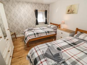 a bedroom with two beds and a mirror at Tyn Y Giat in Gaerwen