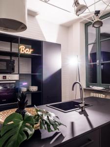 a kitchen with a sink and a bar sign on a cabinet at Le Logge in Parma