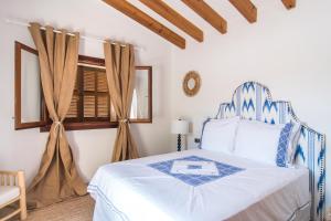 Un dormitorio con una cama azul y blanca y una silla en Villa Pula Golf by Priority, en Son Servera