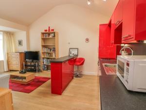 a kitchen with red cabinets and a red stool at Troloss Lodge in Thornhill