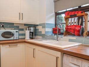 cocina con fregadero y microondas en Glebe Hall Apartment en Marske-by-the-Sea