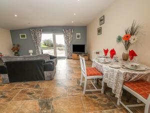 a living room with a table and a couch at Knott Lodge in Milnthorpe