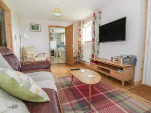 uma sala de estar com um sofá e uma mesa em The Stable at Church Farm House em Cantley