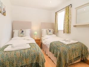 two twin beds in a room with a window at Cornel Glyd in Dyffryn