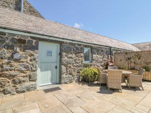 a stone cottage with a blue door and a table and chairs at Cornel Glyd in Dyffryn