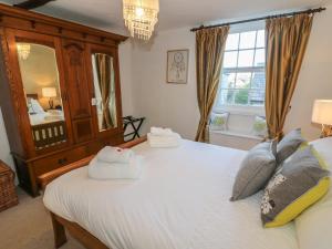 カークビー・ロンズデールにあるCosy Cottageのベッドルーム1室(大きな白いベッド1台、タオル付)