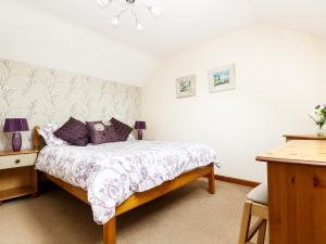 een slaapkamer met een bed met paarse kussens bij The Shippon in Launceston