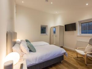 Un dormitorio con una cama, un escritorio y un televisor. en Chy Lowen, en St Ives