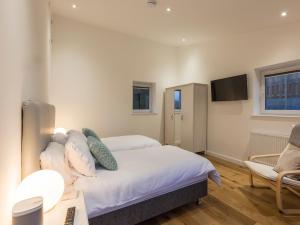 a bedroom with a bed and a desk and a tv at Chy Lowen in St Ives