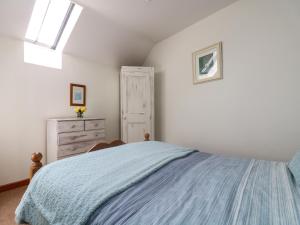 a bedroom with a blue bed and a dresser at The Wagon House in Launceston