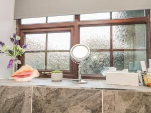 a bathroom counter with a mirror and a window at Glebe Hall Apartment in Marske-by-the-Sea