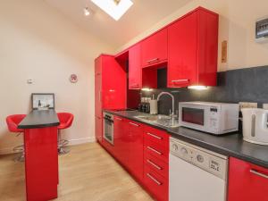 a red kitchen with red cabinets and a counter at Troloss Lodge in Thornhill