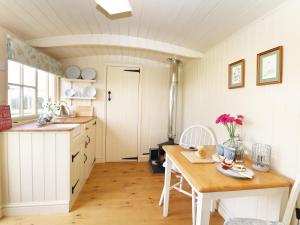 a kitchen with a wooden table and a table and a dining room at Bramble in Wadebridge