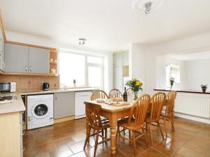 a kitchen with a table and chairs in a room at The Coach House in Trevilley