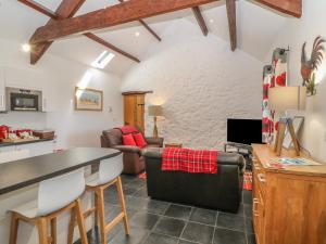 cocina y sala de estar con mesa y sillas en Cornel Glyd, en Dyffryn