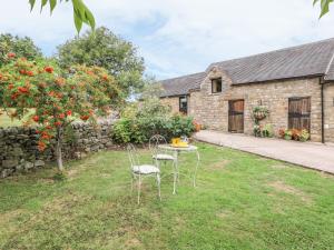 a table and chairs in the yard of a stone house at The 'Stables' in Waterfall