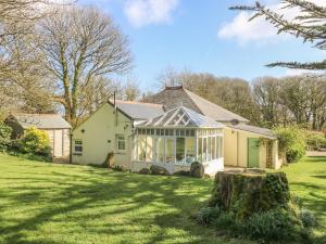 uma casa com uma estufa num quintal em Boskednan Wartha em Penzance