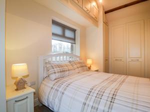 1 dormitorio con cama blanca y ventana en Carwinley Mill House Cottage, en Canonbie