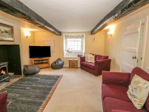 a living room with couches and a tv and a fireplace at Town End Farmhouse in Newby Bridge