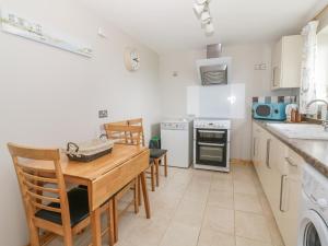 a kitchen with a wooden table and chairs in it at The Stable at Church Farm House in Cantley