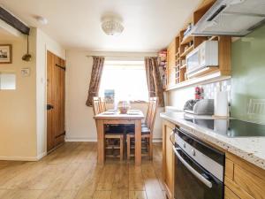 a kitchen with a table and a counter top at Barn Roost in Uldale