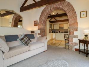 a living room with a couch and an archway at Carwinley Mill House Cottage in Canonbie