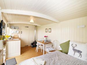 a room with a bed and a kitchen with a table at Bramble in Wadebridge