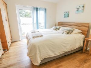 een slaapkamer met een groot bed en een groot raam bij Beachcombers in Newquay