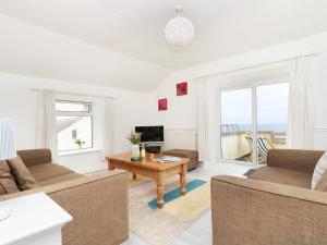 a living room with a couch and a table at The Coach House in Trevilley