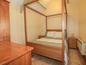 a bedroom with a four poster bed with a mirror at Barn Cottage in Liskeard