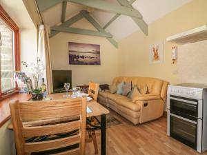 a living room with a couch and a table at Barn Cottage in Liskeard