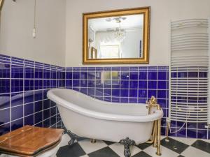 ペンザンスにあるBoskednan Warthaの青いタイル張りのバスルーム(バスタブ、鏡付)