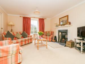 a living room with couches and a fireplace at Goshen Farm in St. Agnes 