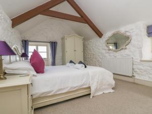 a bedroom with a large white bed with pink pillows at Boar's House in Penzance