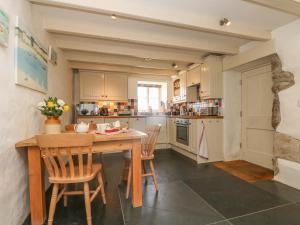 a large kitchen with a wooden table and chairs at Boar's House in Penzance