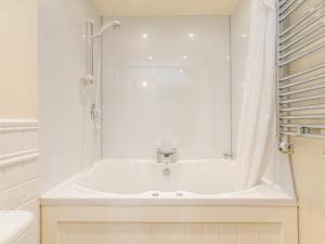 ein weißes Badezimmer mit Badewanne und Dusche in der Unterkunft Jenny's Cottage in Alnwick + 25 Fotos