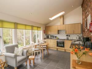 a kitchen with a table and chairs in a room at Beck Cottage in Ulverston