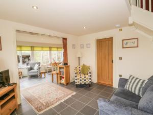 a living room with a couch and a tv at Beck Cottage in Ulverston