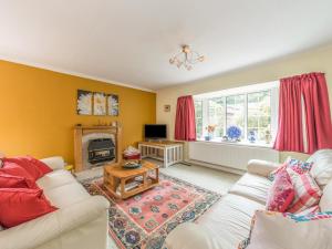a living room with a white couch and a fireplace at Sunny Corner in Church Stretton