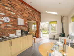 a kitchen and dining room with a brick wall at Beck Cottage in Ulverston +11 photos