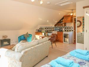 a living room with a couch and a kitchen at The Loft in Bradwell