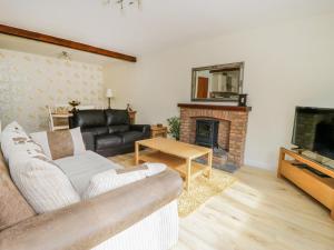 a living room with a couch and a fireplace at The Milking Parlour in York