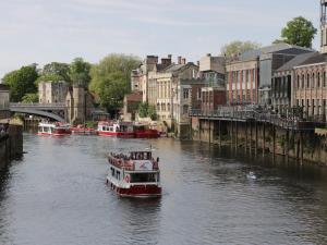 a boat traveling down a river in a city at The Milking Parlour in York
